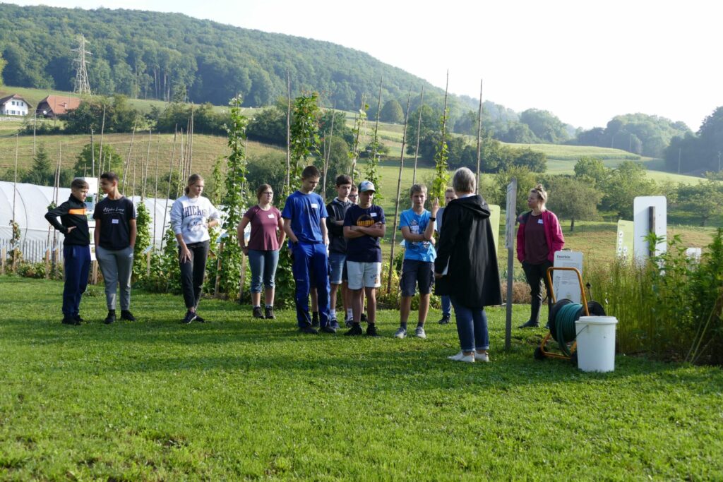 Eine Schulklasse besammelt sich auf dem Weltacker Attiswil.