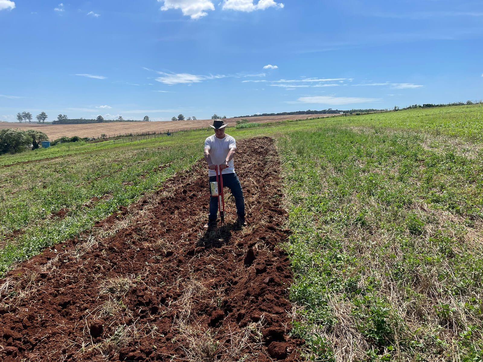 A man is working on the field and preparing the soil for sowing.