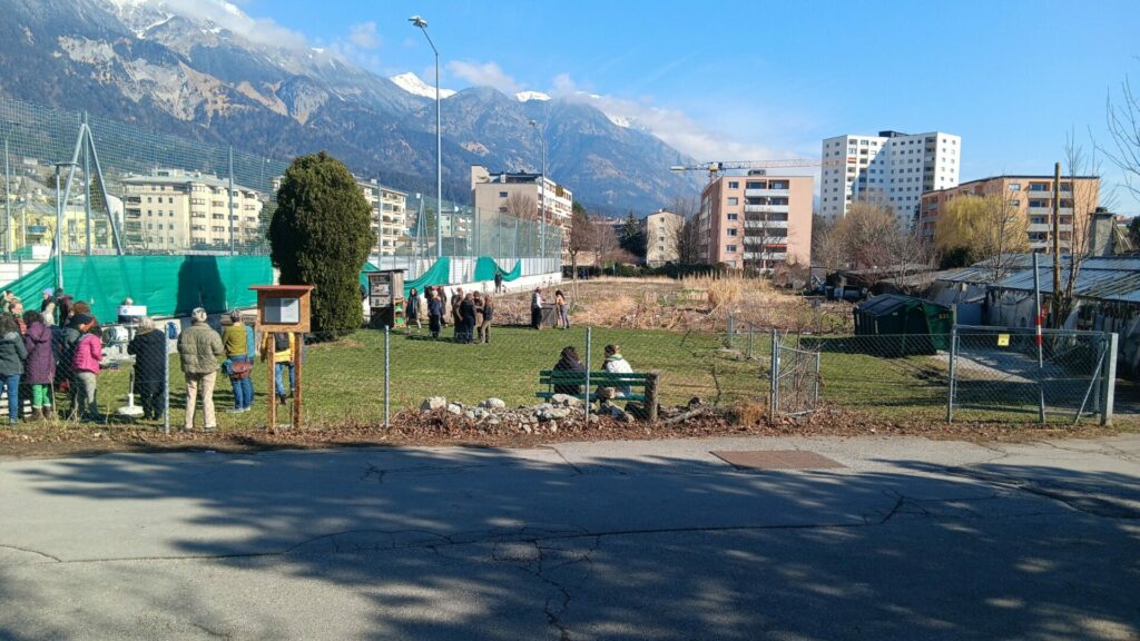 Umgeben von Hochhäusern und angrenzend an einen Fußballplatz sieht man den Weltacker in Innsbruck.