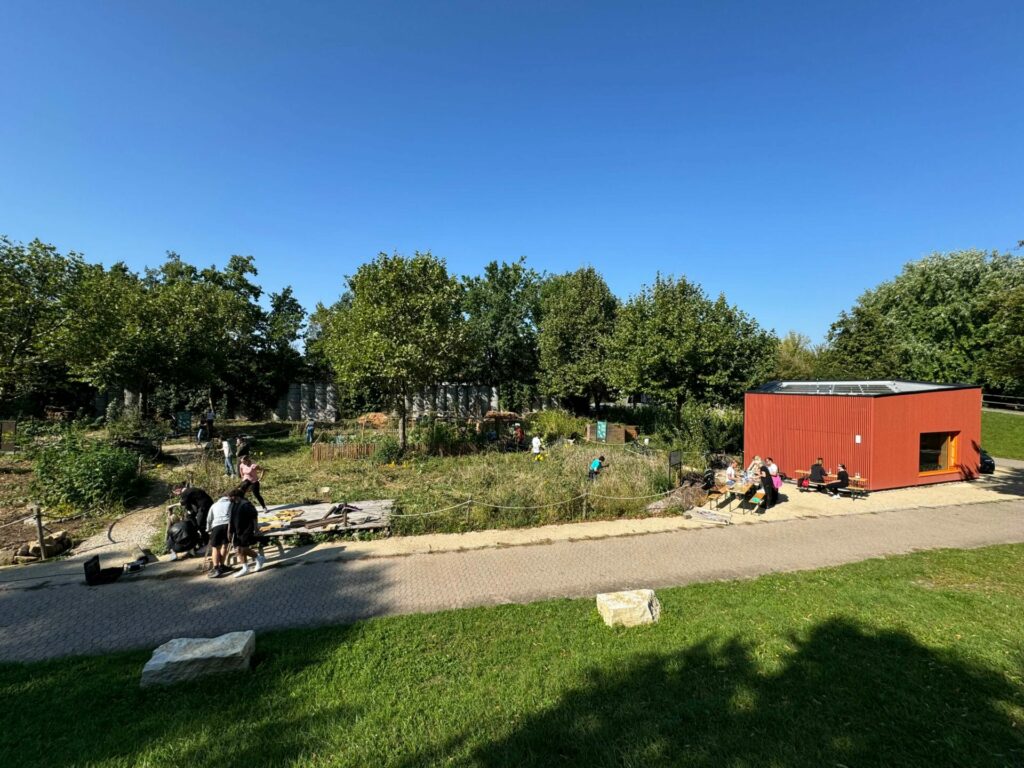 Blick auf den Weltacker Nürnberg - zu sehen ist der Weltacker im Park und daneben das rote Weltacker-Haus.