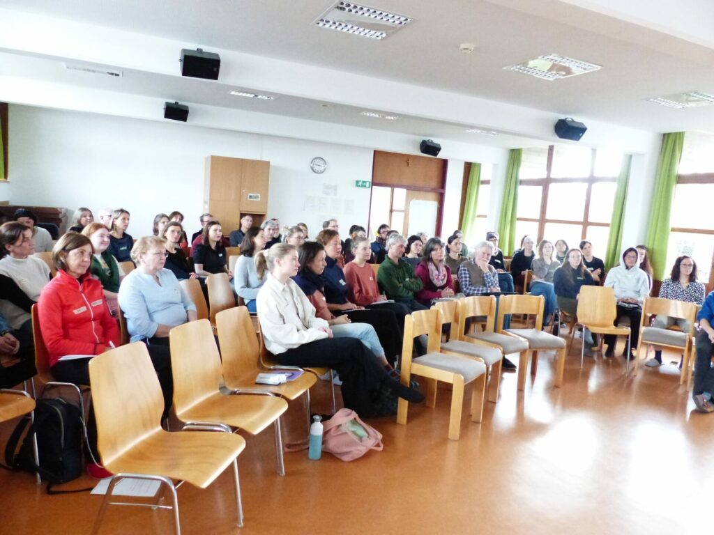 Die Teilnehmenden der Weltacker-Konferenz sitzen im Plenumsraum und folgen aufmerksam dem Vortrag.