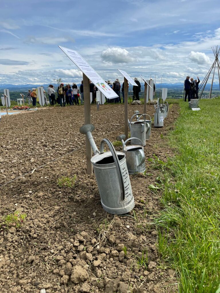 Labeled watering cans at the edge of the field explain the different water statistics around the world.  