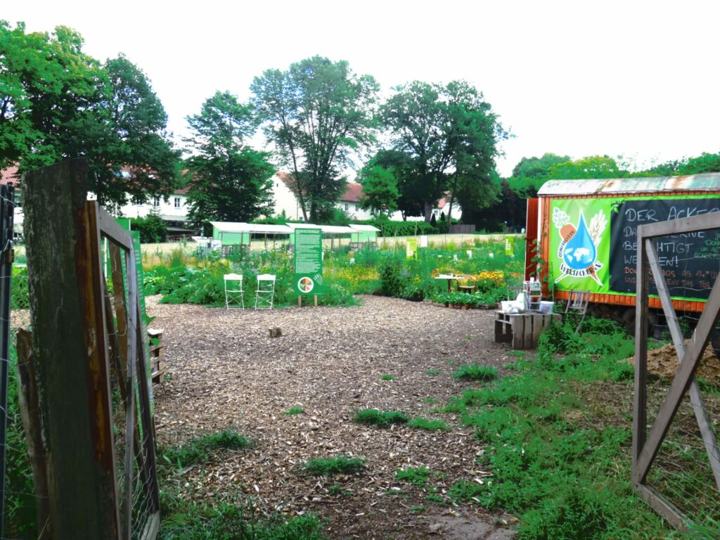 The entrance to the Weltacker Osnabrück: view of the one construction trailer, the crop fields and signage.  