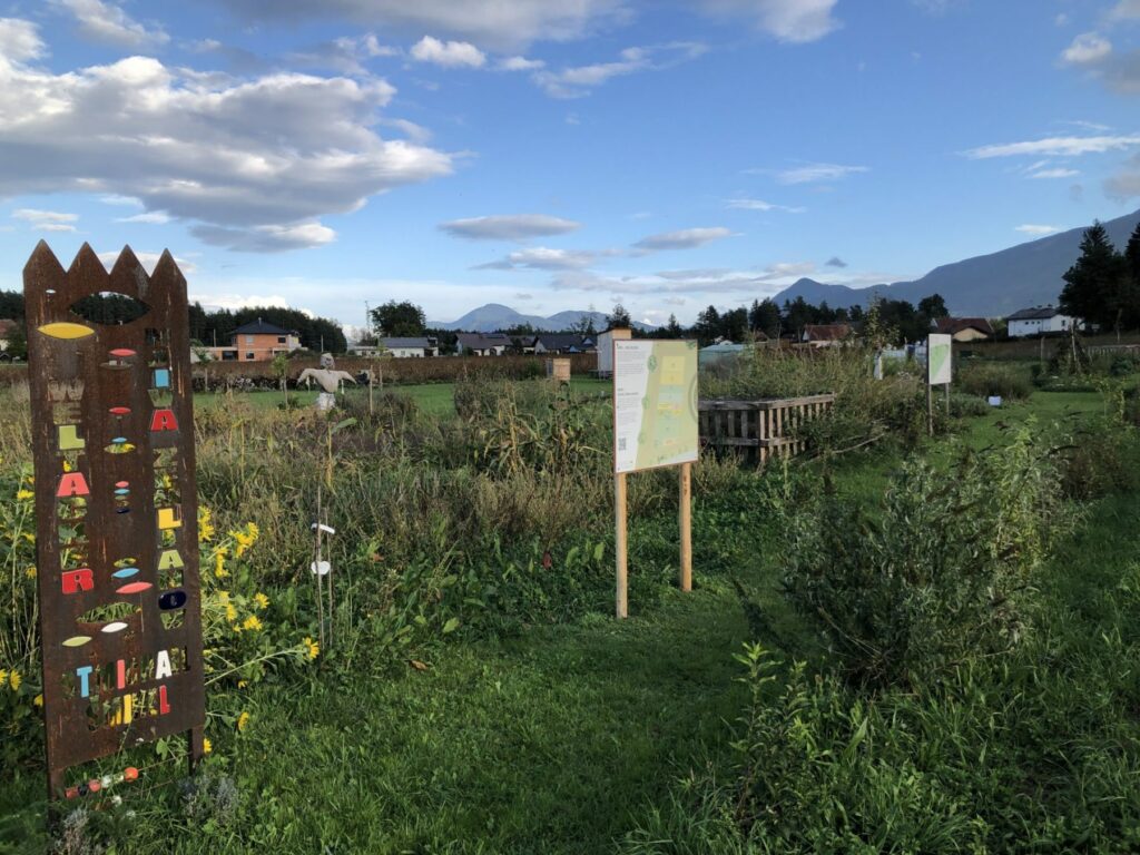 At the entrance to Global Field there is a bilingual welcome sign in front of the plants of the Weltacker.