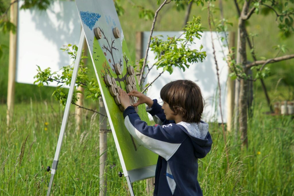 A little boy moves magnetic signs around on a blackboard - a game to learn about the seasonality of crops.  